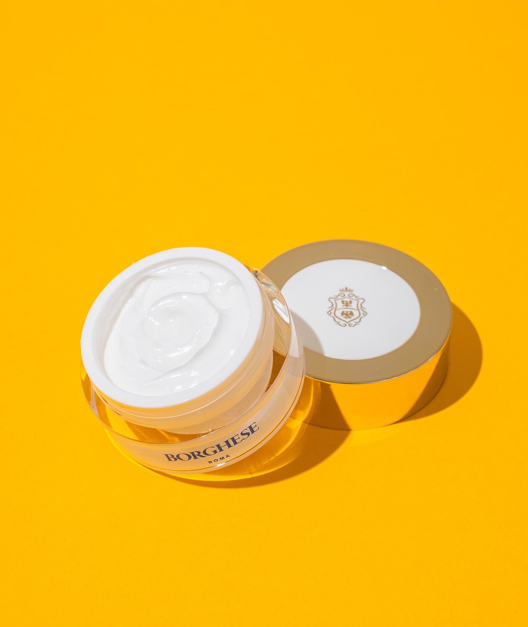 Image of jar open on a yellow background showing the smoothing and hydrating Occhi Ristorativo Eye Creme