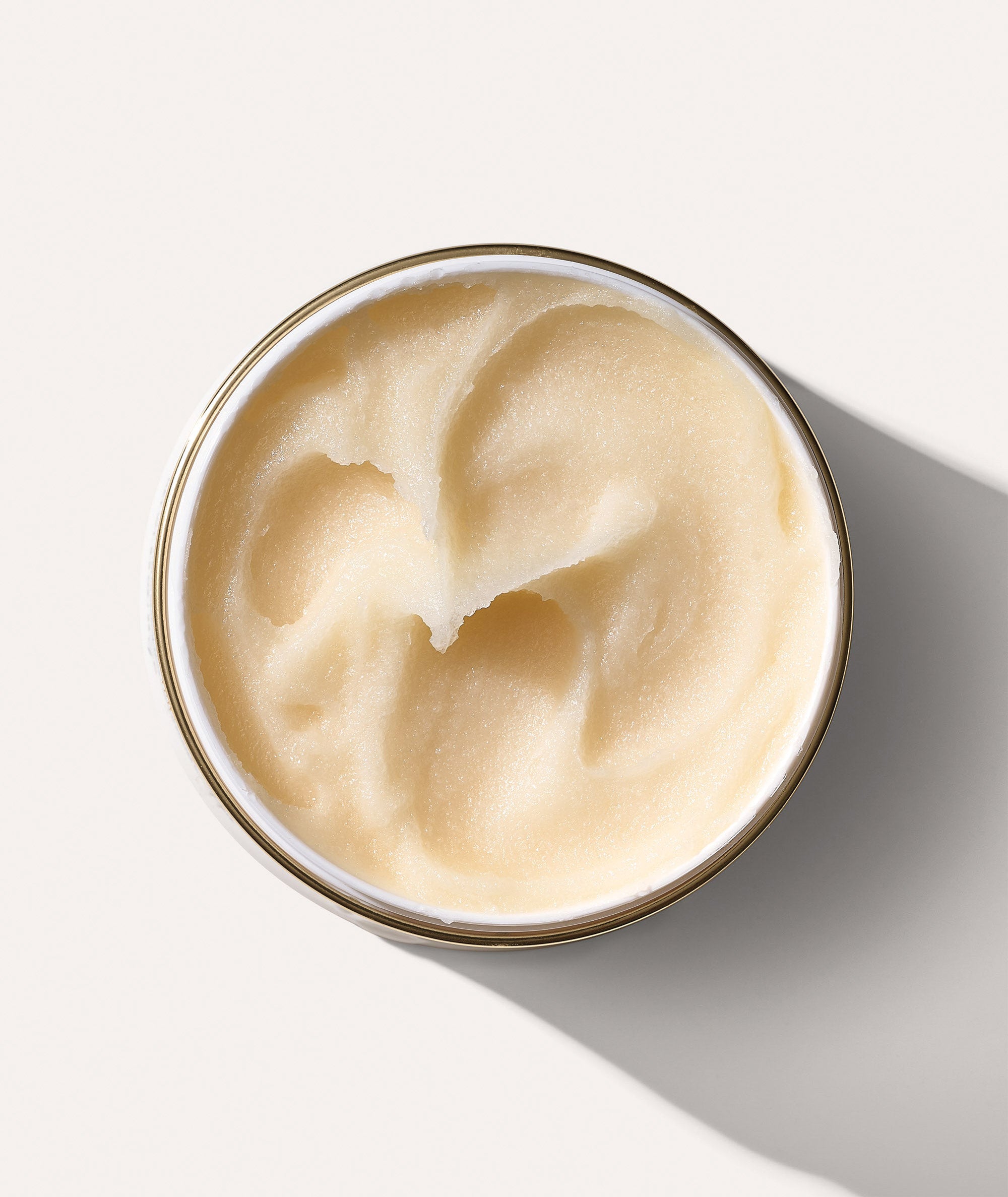 Aerial view of an open Rinfrescante Body Polish jar, showing the thick texture of the sugar scrub